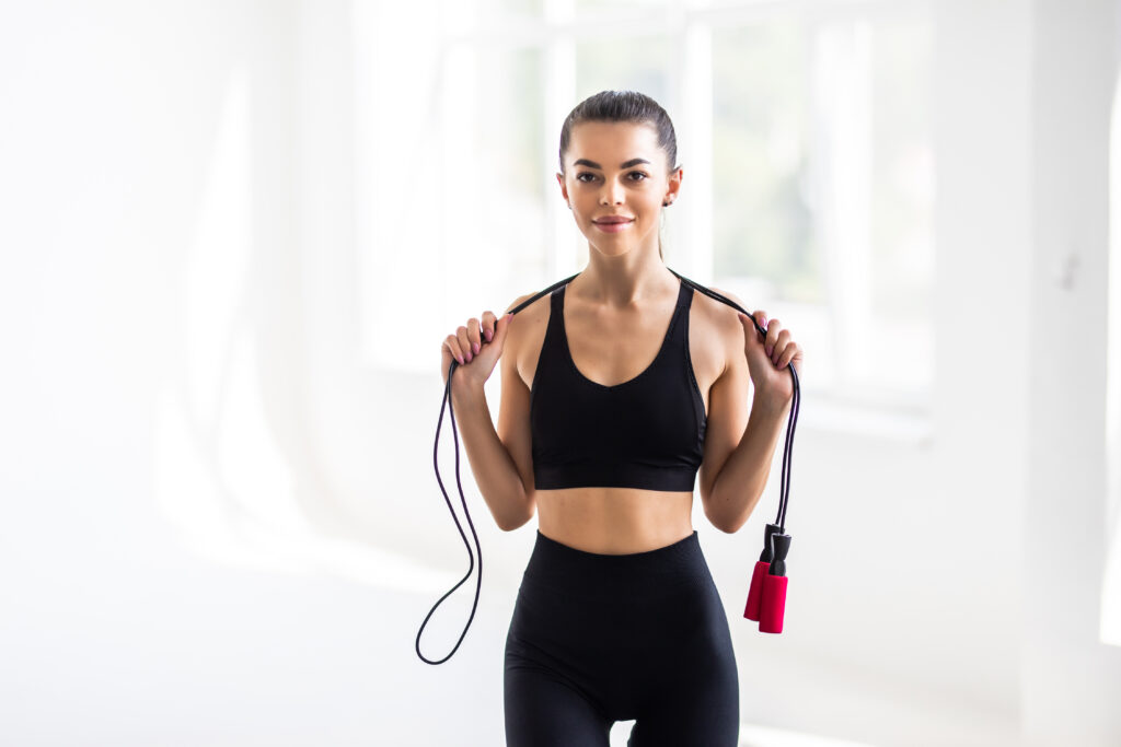 femme souriante sportive faisant de la corde à sauter